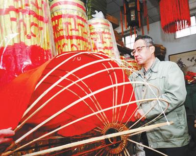 北京市美术红灯厂工人将红色布料贴在骨架上.本报记者贺勇摄.